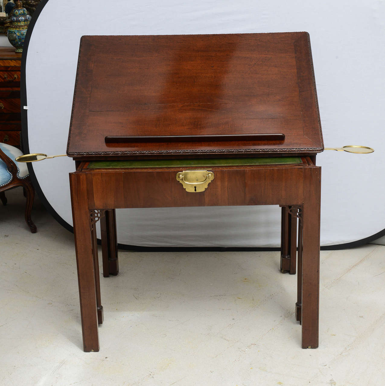 Very fine Georgian era architects desk made of mahogany. The top of the table is adjustable to various plane angles, while the green leather writing portion slides out. When open there is a hidden side compartment which neatly nestles into the side