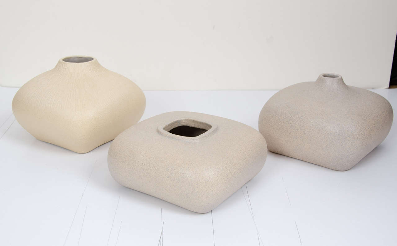 These three square shaped vessels are produced in stoneware clay. The openings are shaped in circular and square forms. Two forms have a subtle speckled surface and one has a scratched texture.

Dimensions;
H 7 W 17 x 17.
H 10 W 17 x 17.
H 12 W