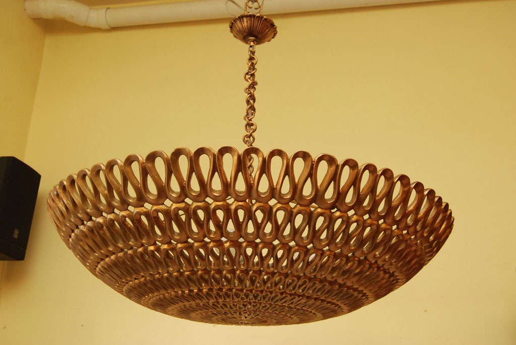 A convoluted design ceiling fixture made from a guilted composition with 4 lights in the center.