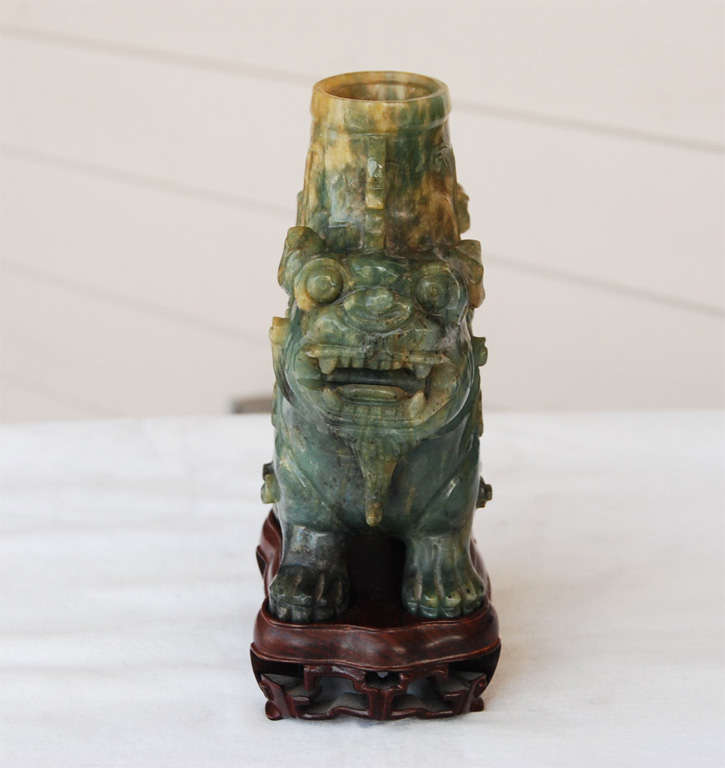 This fine jade urn of a lovely spinach color running to a deep yellow is carved to resemble a pair of Buddhist lions or mythical beasts conjoined back to back resting upon clawed feet. The body of the urn is covered in a single low relief Archaistic