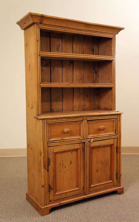 A typical one piece Irish Open Rack Dresser-featuring two upper shelves, two lap-jointed molded drawers and two panelled doors, the whole surrounded by hand-cut fluting and ending in a delicate bracket foot - except that it is only 51