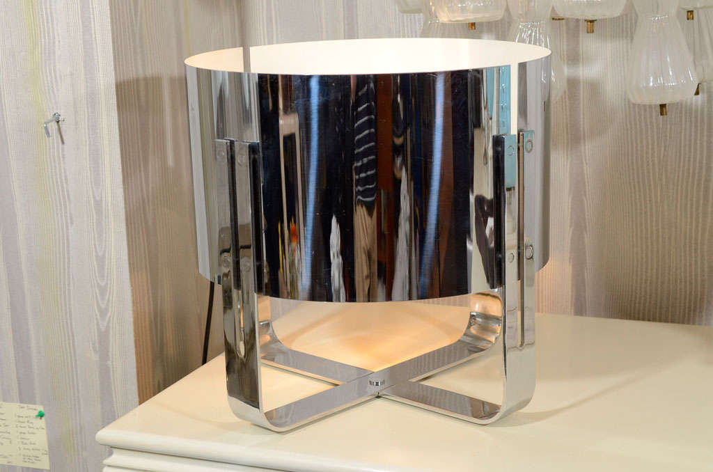 Italienische Tischlampe mit verchromtem Schirm aus den 1970er Jahren von der bekannten Beleuchtungsfirma Lumenform. Innen weiß emailliert, mit einer einzigen seitlichen Steckdose. Zwei separate Teile bilden den Schirm, der von zwei U-förmigen Beinen