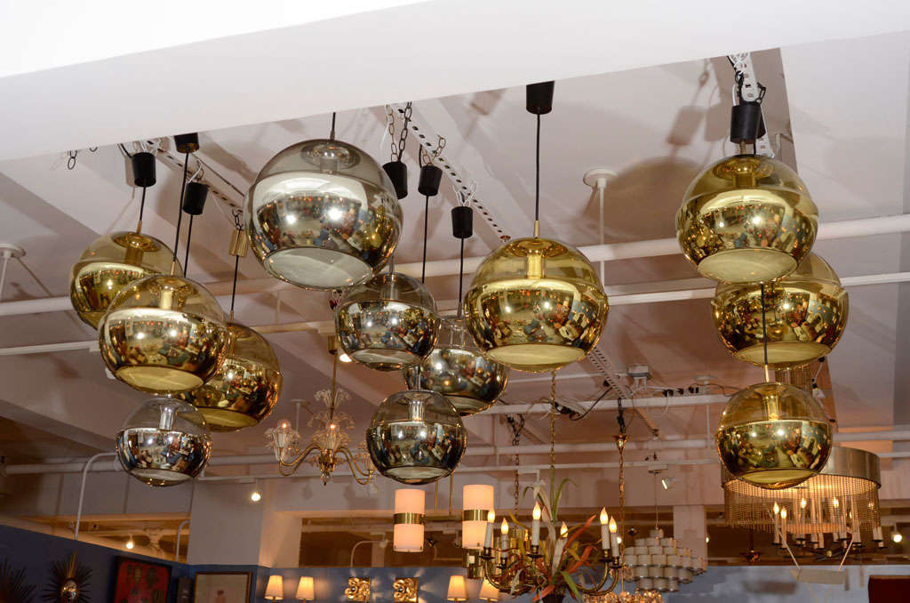 Group of nine spherical glass chandeliers, with silver or gold foil interior band on bottom half encased in clear glass, by Peill and Putzler, German 1960s. In three diameters 10 3/4 in (1 gold), 13 3/4 in (1 silver, 4 gold), 17 3/4 in (1 silver, 2