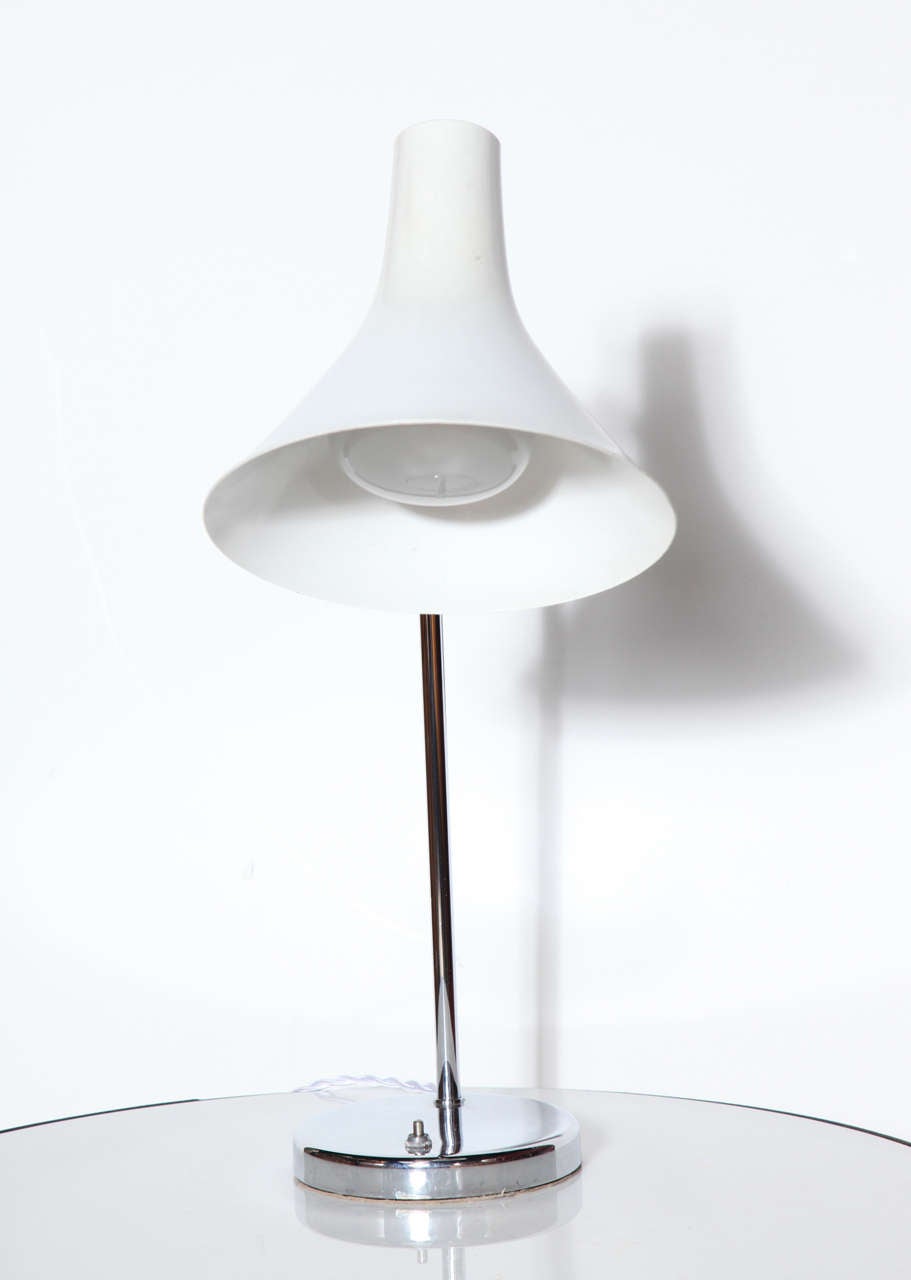 Classic Nessen Studios (Model #NS966) Chrome and White Enamel Table Lamp. Featuring a perforated slightly adjusting, modern bell shaped White enameled Aluminum shade, fully rotating Chrome arm on reflective, round Chrome-plated 6D base.  With base