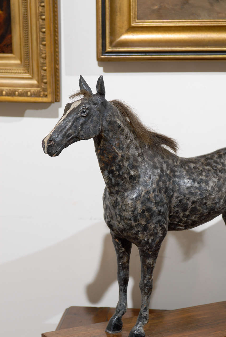 This English late 19th century sculpture from the Victorian era features a grey colored horse with dark spots standing on a rectangular rosewood veneered base. With its slightly raised tail and alert stance, this fit horse looks like it might be