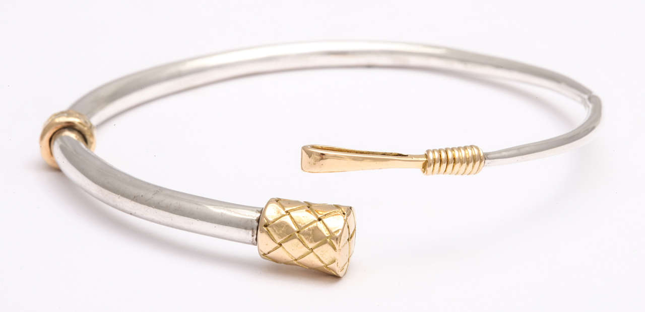 Equestrian style sterling silver bangle in the form of a riding whip by Hermes Paris.  Very beautifully detailed with 18kt gold, which is engraved and wrapped to mimic the whip. Signed 