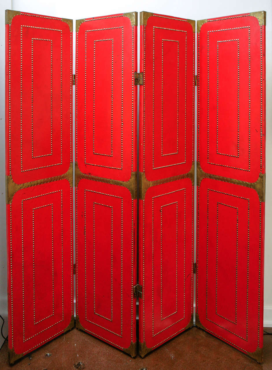 Incredible folding screen clad in red leather, brass studs, and brass detailing, circa 1940.