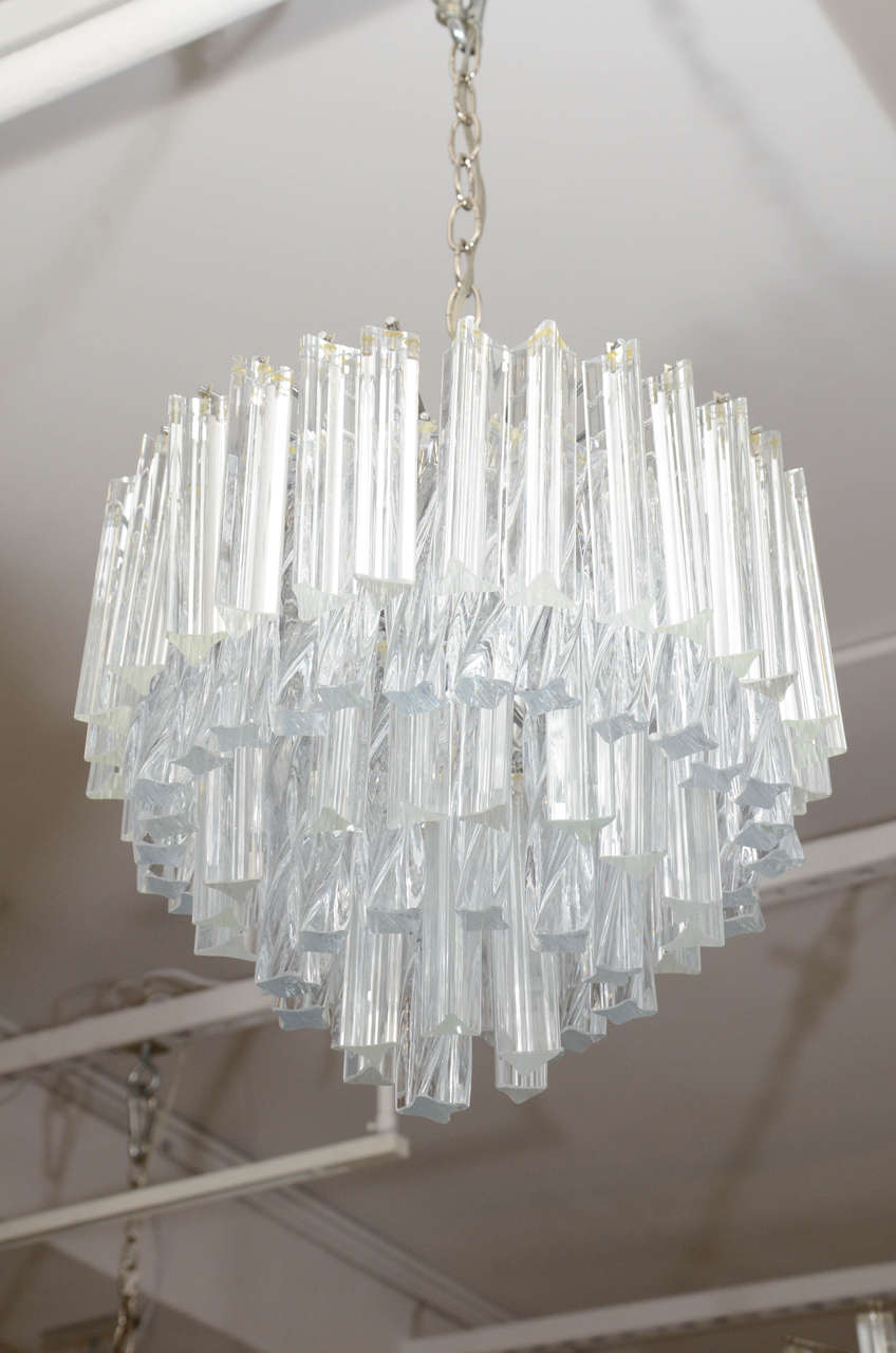 Pair of Murano glass chandeliers composed of alternating tiers of hand blown triedri crystal prisms and twisted quadriedri crystals. The polished nickel frame has 4 lights, rewired to US standards. These chandeliers are new/old stock and have never