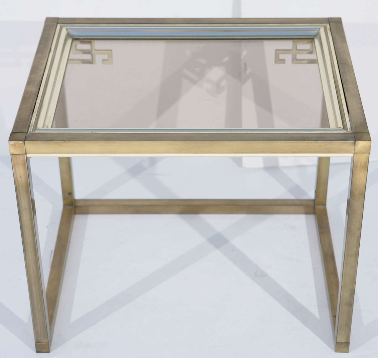 Neoclassical rectangular brass table with glass top and Greek key corner brackets