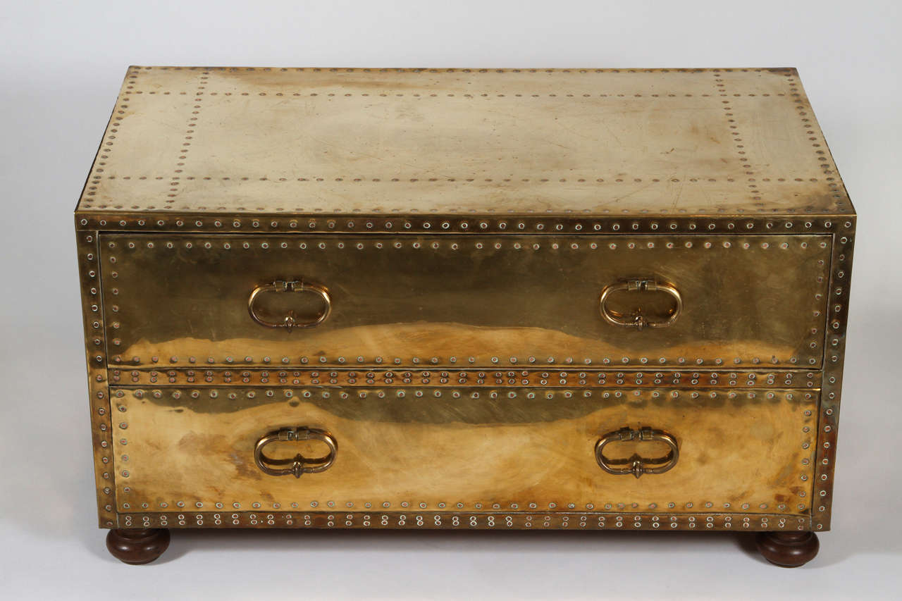 Vintage trunk with two drawers encased in brass with copper trivets. 