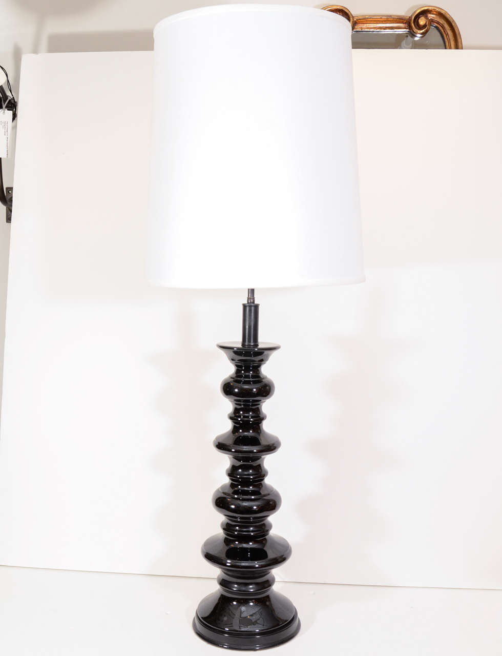 Pair of dramatic glossy black ceramic table lamps.  USA, circa 1950.  Recently restored/rewired.

Dimensions:
39 inch height to finial
22 inch height of ceramic vessel
8 inch base width