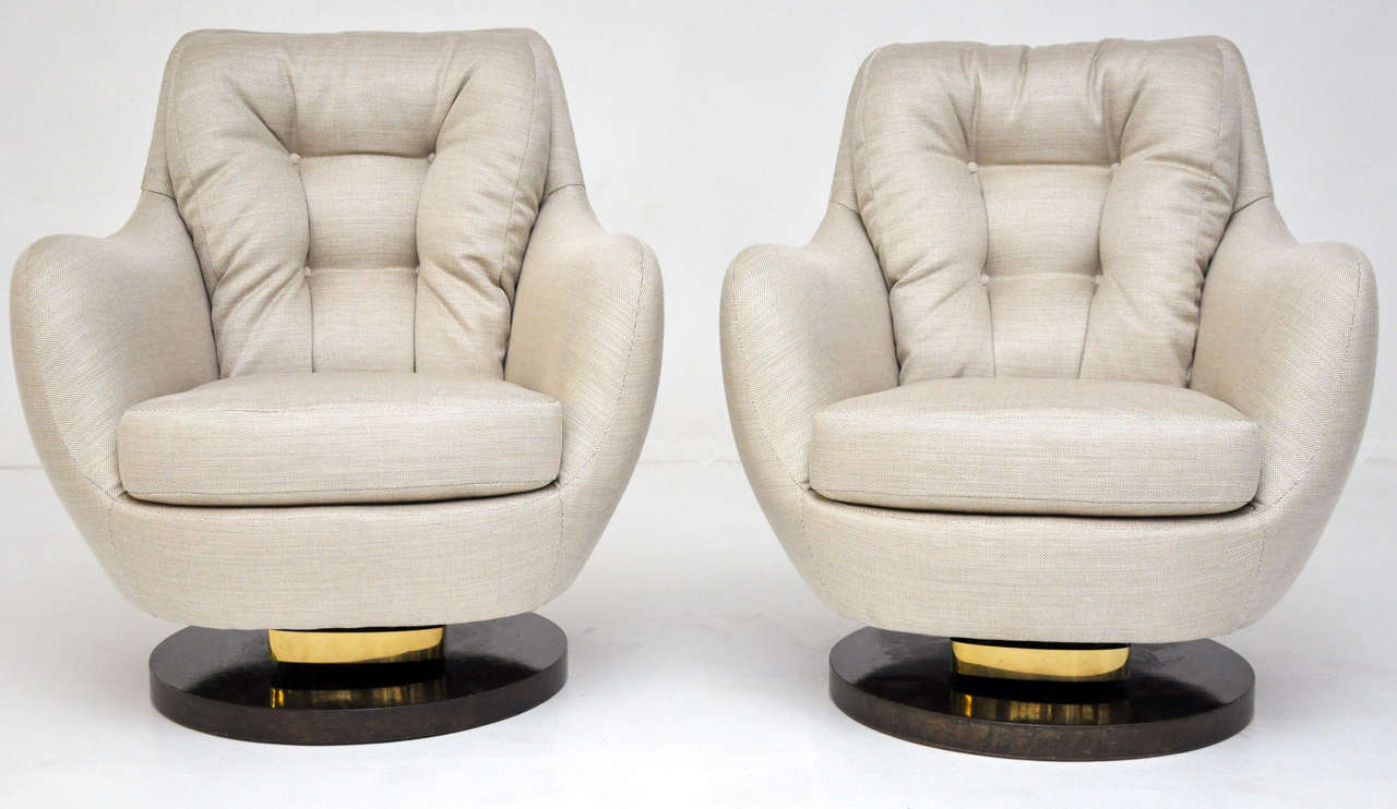 Lounge chairs by Milo Baughman.  Chairs swivel and rock. Carpathian elm bases with brass.  Newly upholstered.