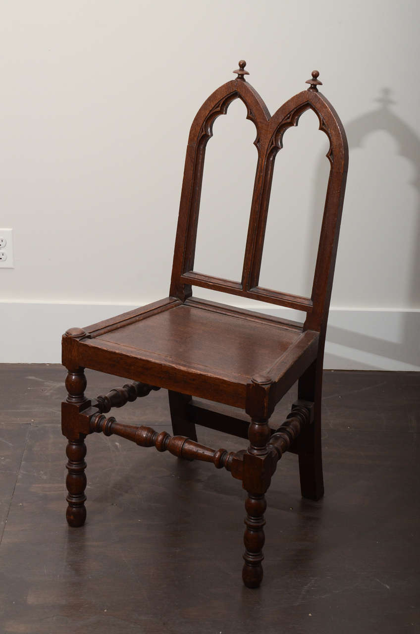 Chaise d'appoint gothique ancienne en chêne, finition sombre. Motif inhabituel en relief sur le dossier - élégants pieds tournés.