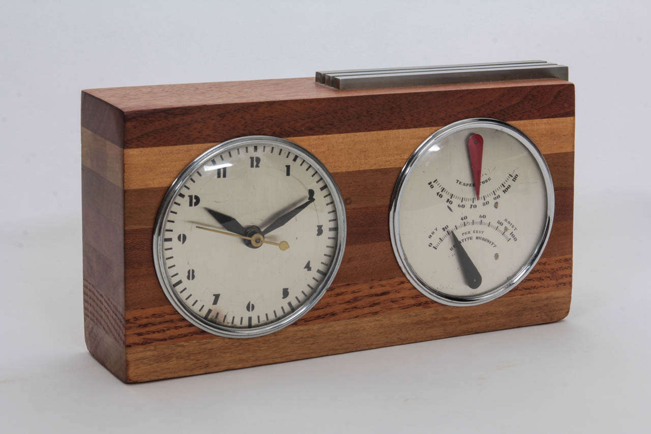 GILBERT ROHDE   (1894-1944)   USA
HERMAN MILLER CLOCK CO.  Zeeland, Mich.
	
Showroom sample clock and thermometer/barometer  c. 1933

Block of seven stacked wood varieties with three brushed chrome bars, chromium-plated rings and original