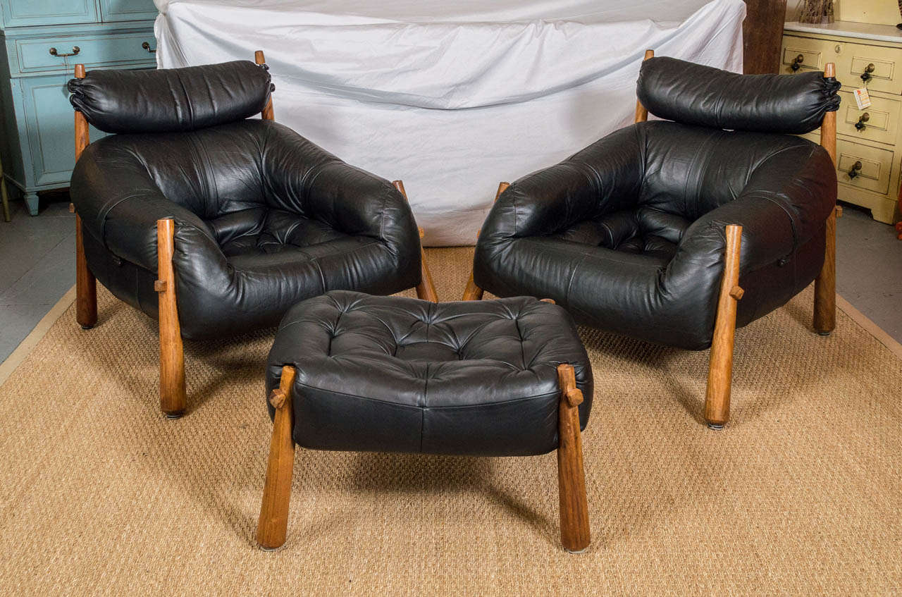 A pair of lounge chairs and ottoman from Brazil, designed by Percival Lafer.
A fiberglass frame with black leather and rosewood legs. Ottoman is 27w x 21d x 16h.