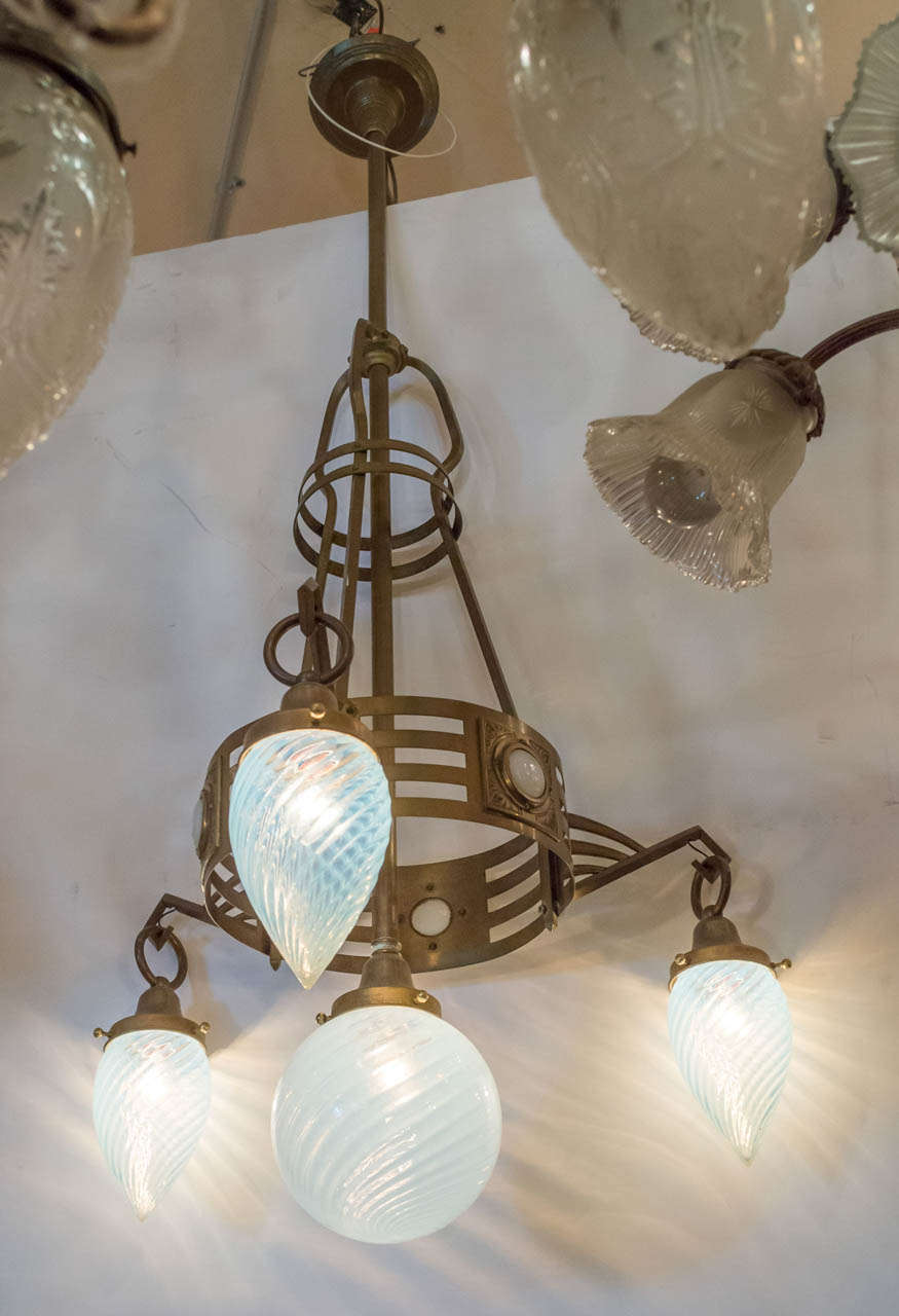 This very clean lined Austrian chandelier shows off the design and style of the secessionist movement. Having four handblown opalescent swirl shades and matching cabochon in the body completes the excellent package.