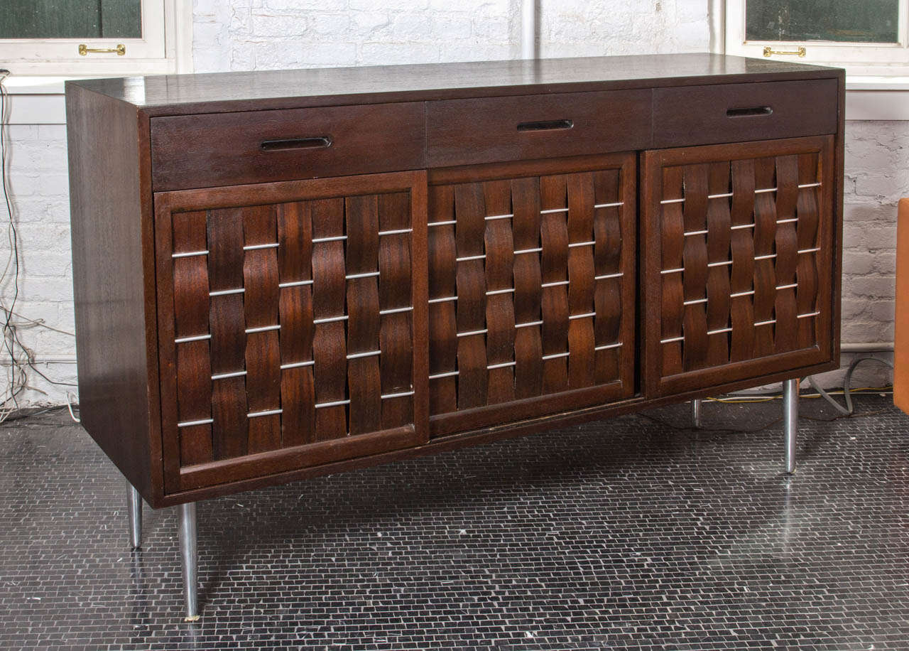 Edward Wormley basket front mahogany sideboard, mfg. Dunbar, on tapering stainless steel legs.