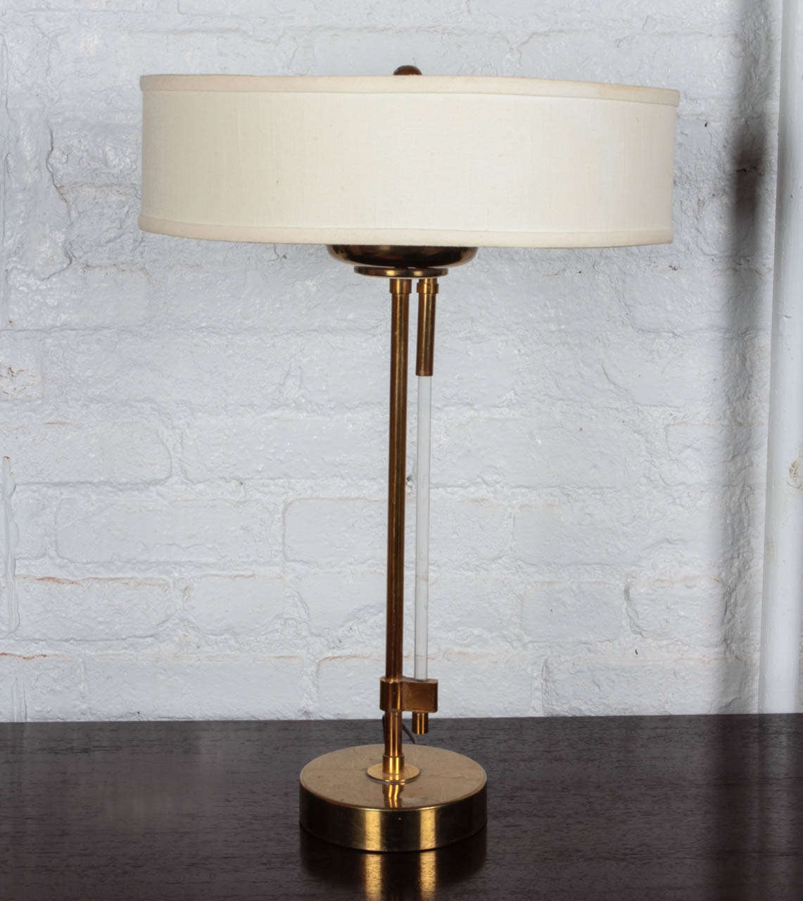 Brass table lamp with brass base and cylindrical lucite switch which pulls down to turn on and off, mfg. Stiffel.