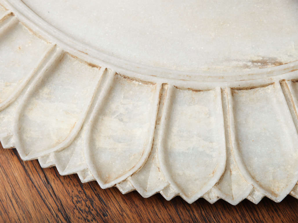 A large vintage white marble platter from India. Measures: 24 inch diameter. Carved tongue pattern around border.