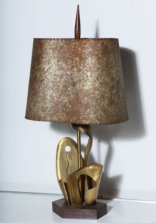 Importante lampe de table en laiton et bois sculpté de l'époque Art Déco de Yasha Heifetz. Cette lampe présente des formes abstraites de plantes et de feuilles en laiton, réalisées à la main, sur une base rectangulaire hexagonale en bois, avec un
