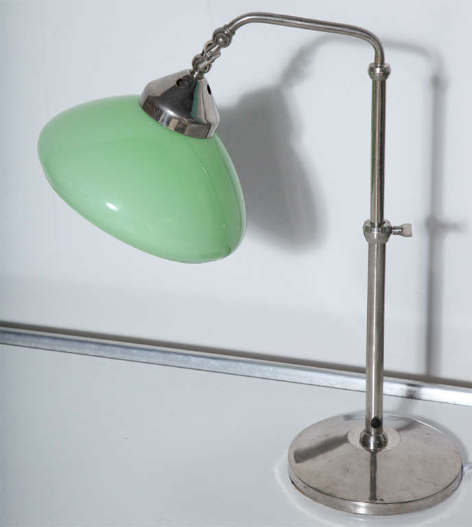 European bankers adjustable desk lamp in nickel-plated brass with pale green glass shade. Featuring an adjustable height nickel plate stem, tilt knob and soft green bell shade with white interior.  Early 20th century. Fine quality. Made in Italy.