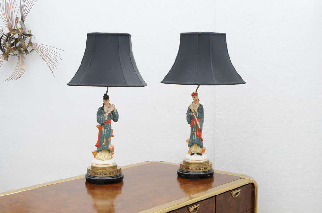 Wonderful pair of male female porcelain ceramic table lamps on original brass and wood bases. Perfect original working order and sold with black silk shades.
Original round brass chinoiserie finials have been found and will be included.