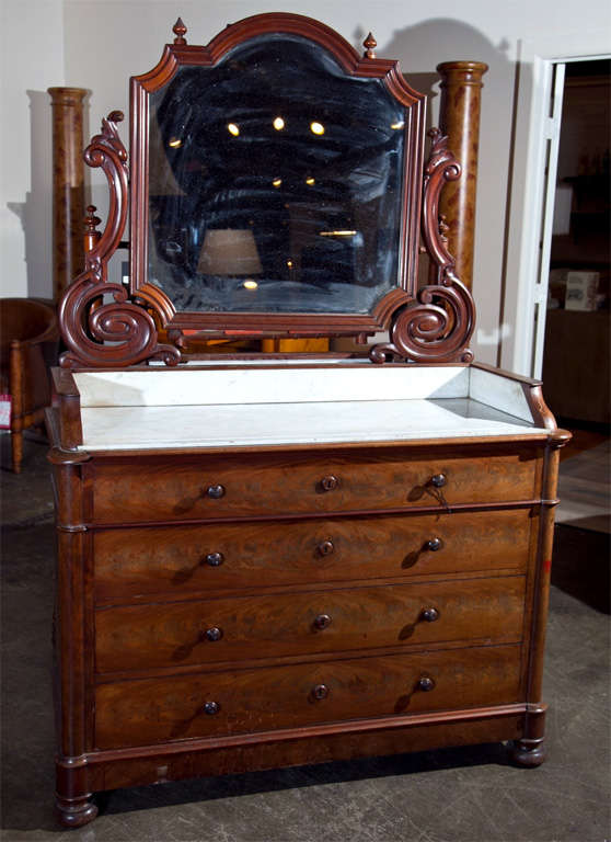 French mahogany dressing vanity with mirror, c. 1880, the chest of four long drawers, column mounts and bun feet. The top is a mahogany trimmed white marble with gallery and mahogany mounted pivoting mirror. Will make a great contemporary vanity.