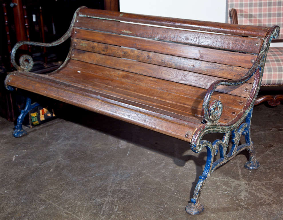 Cast iron and teak garden bench, c. 1900, with several layers of old paint showing through on the iron, and good patina on the teak. From a public garden in Jodhpurs, India