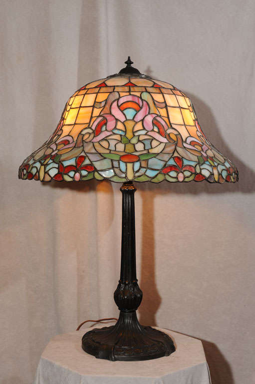 This very colorful and unusual shaped leaded glass table lamp is signed by the maker 