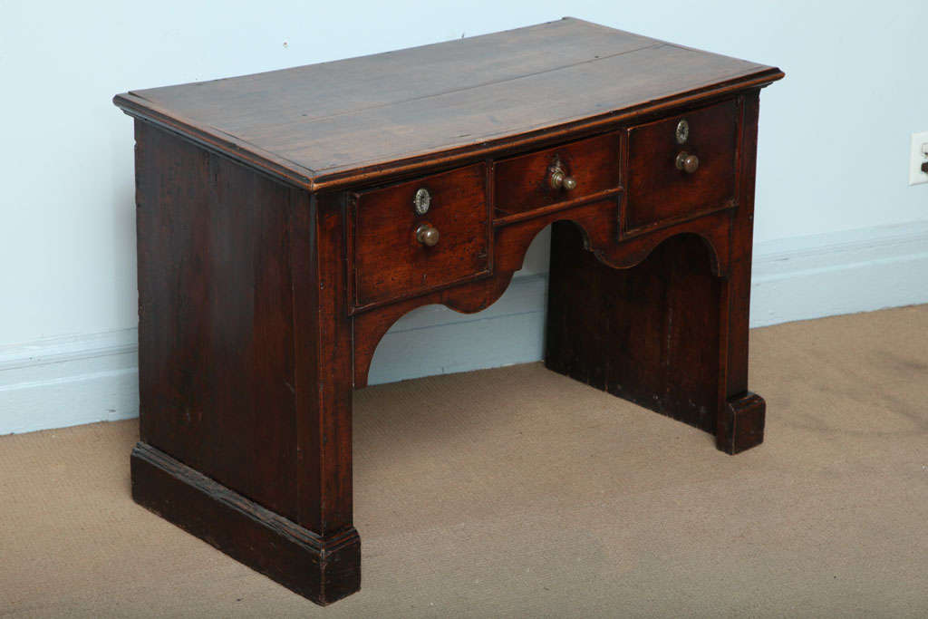 An unusual English 18th century fruitwood lowboy or dressing table having richly molded top over three drawers and solid sides, finished with molded feet. Good color and rich patina. Overall of very architectural form. circa 1760.
 
This lowboy