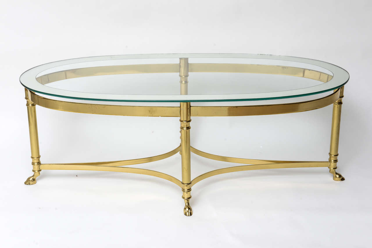 in the Style of Maison Bagues From Paris France .
This Oval Coffee Table is fitted with 4 Hoof feet and a Mirrored Rim Glass Top.