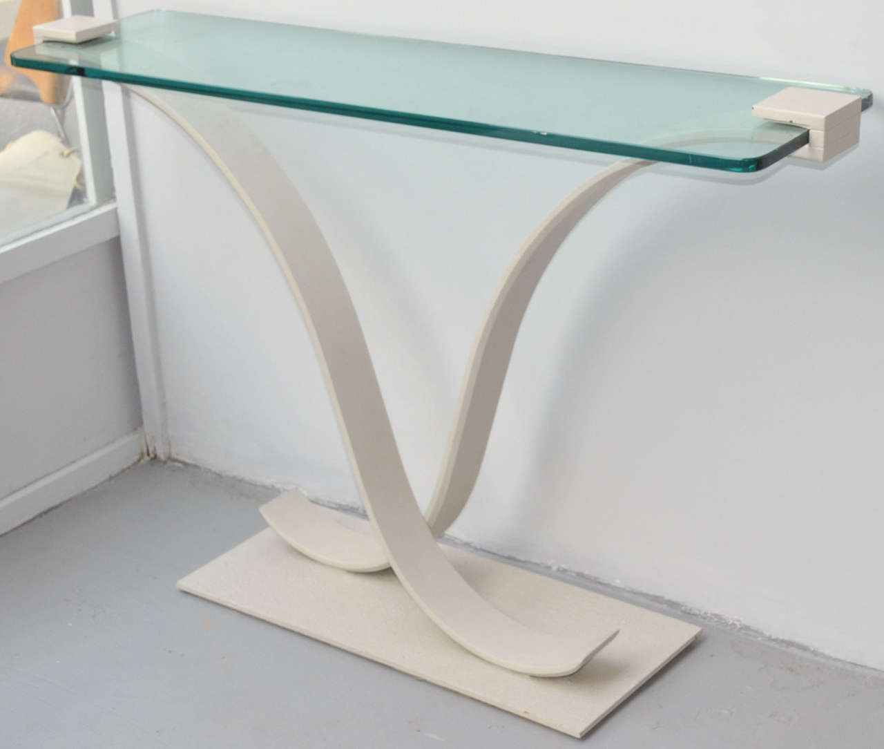 1980s console table with base in off-white patina metal and glass top.