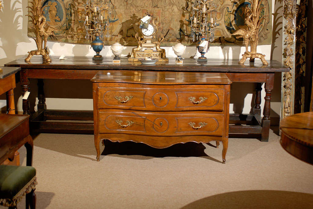 Louis XV walnut two drawer commode with serpentine front, brass hardware and shaped apron. All resting on hoofed feet. 

