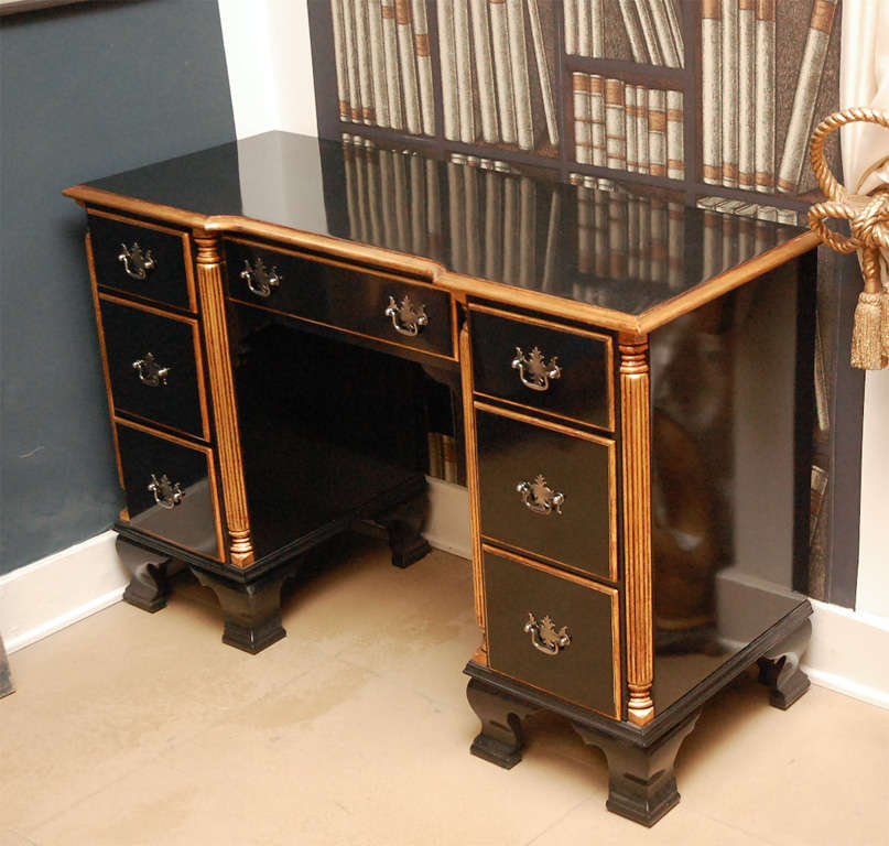 7 drawer Federal style desk finished in black and gold lacquer and brass hardware.