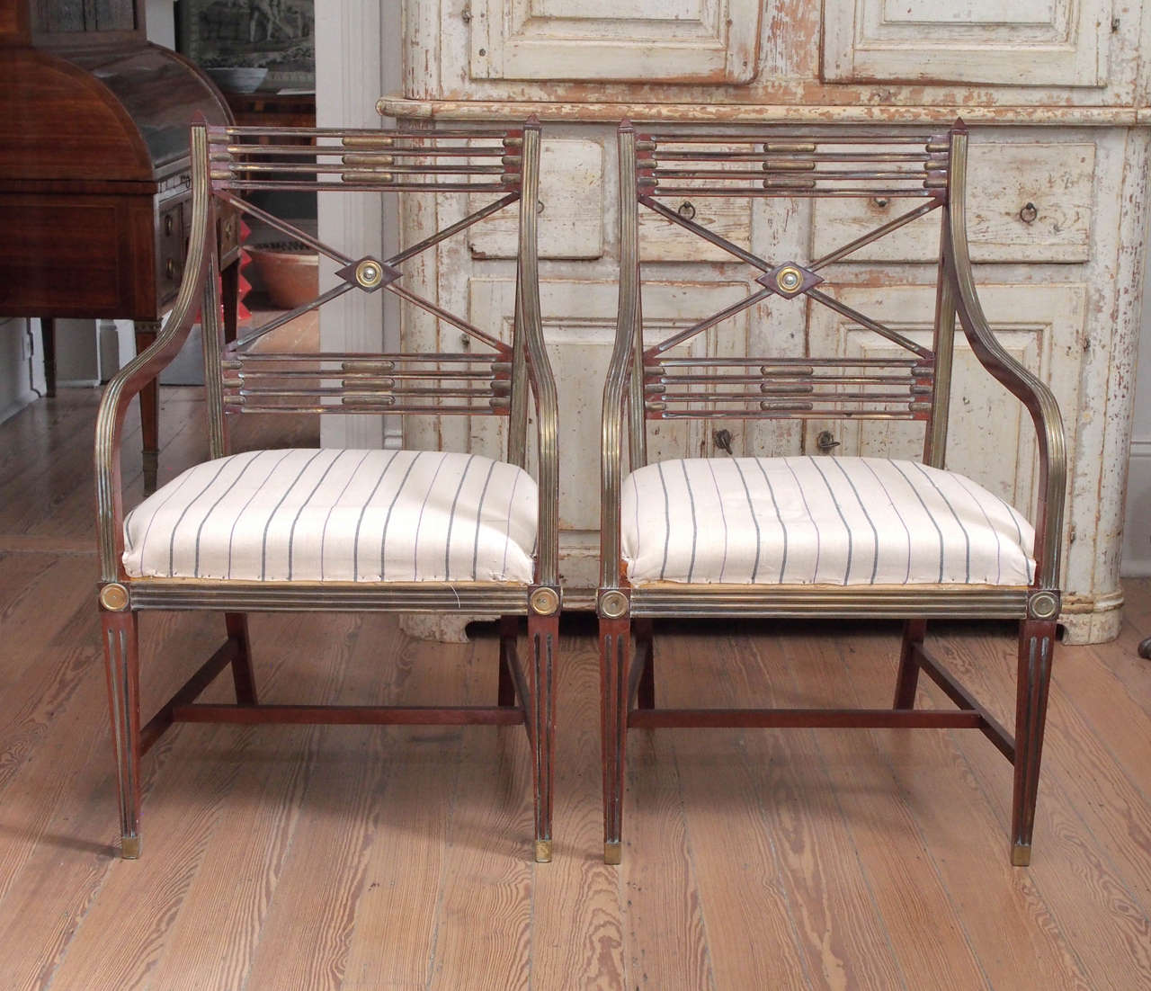 Pair of Russian mahogany armchairs with brass decorative elements.