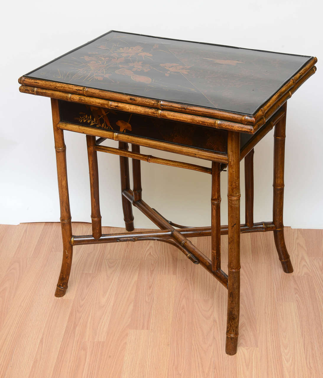 Incomparable and rare 19th Century English Bamboo Game Table. The Japanned top is painted with gilded birds - superb pen work - nearly original condition. The interior is equally finishished with gild highlights . This is highly stylized and