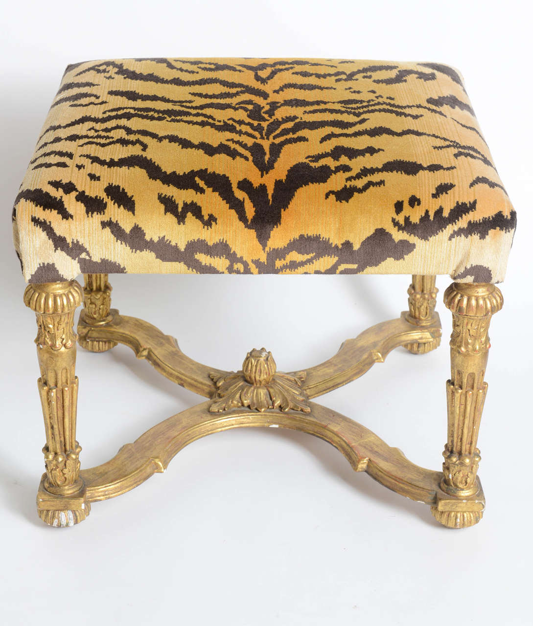 Elegant carved and gilded bench upholstered with Scalamandre tiger fabric.