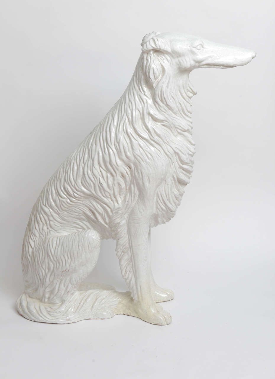 Extremely striking white glazed terra cotta dog seated (Russian Wolfhound).