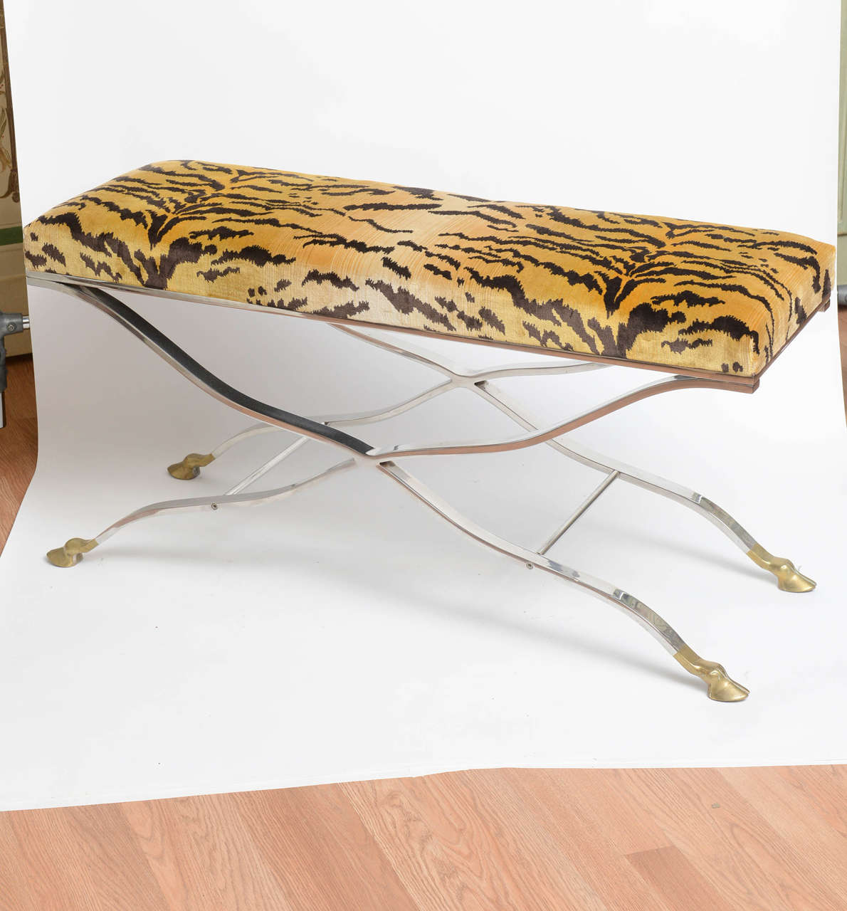 Stunning stainless steel bench with brass hoofed feet. New cushion upholstered in Scalamandre 