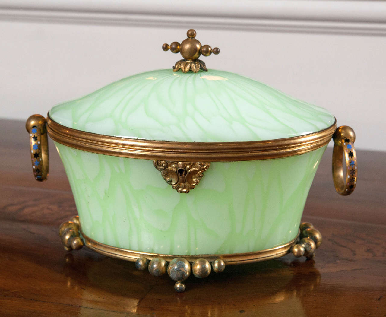A lime swirl pattern opaline glass oval hinge covered box with bronze mounts and Champlevé enamel handles. 
