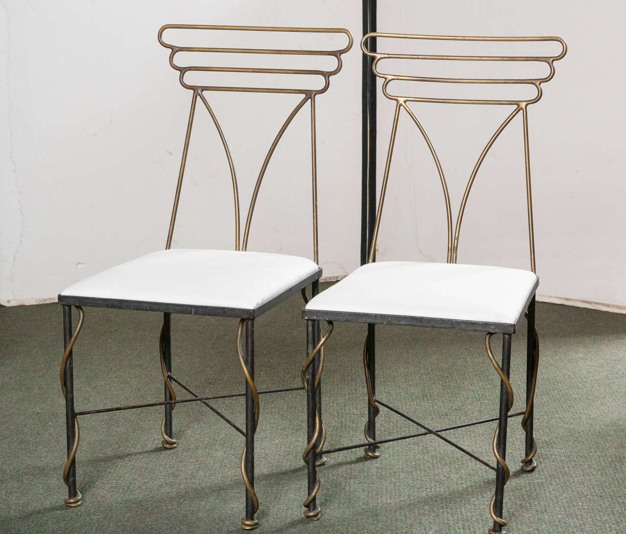 A set of four French sculptured bronze and iron side chairs in the manner of G. Poillerat.