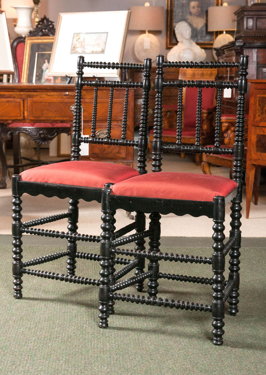 A pair of English ebonized bobbin chairs with silk canvas upholstery.