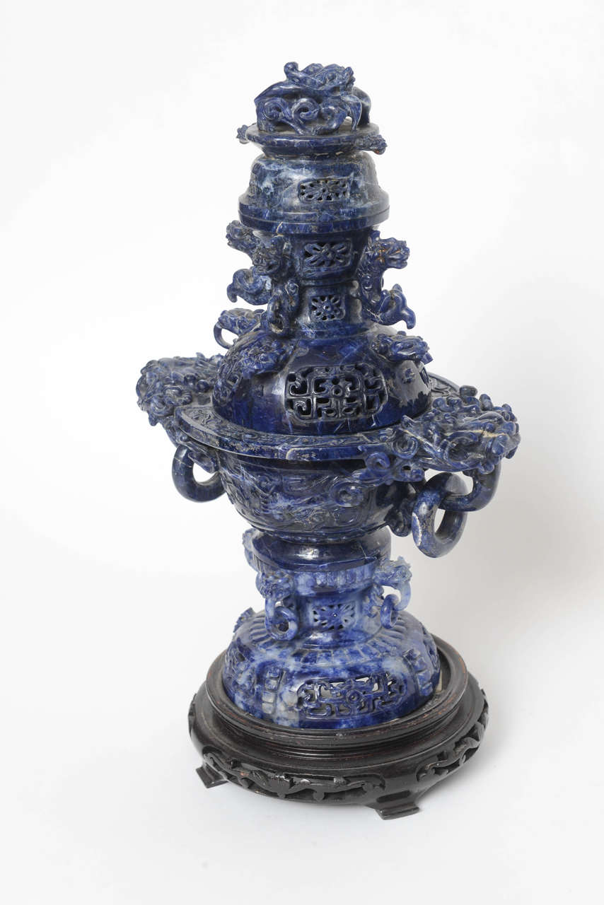 Finely carved in two pieces mounted on a custom carved teak base. Deep blue is one the finest grades of stone.  The stone was appraised as Sodelite.  There are two very small rings & part brackets missing on the very bottom.  You really need to look