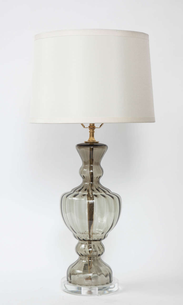 Fantastic pair of Murano glass lamps in a smokey grey color with gored details and lucite bases.