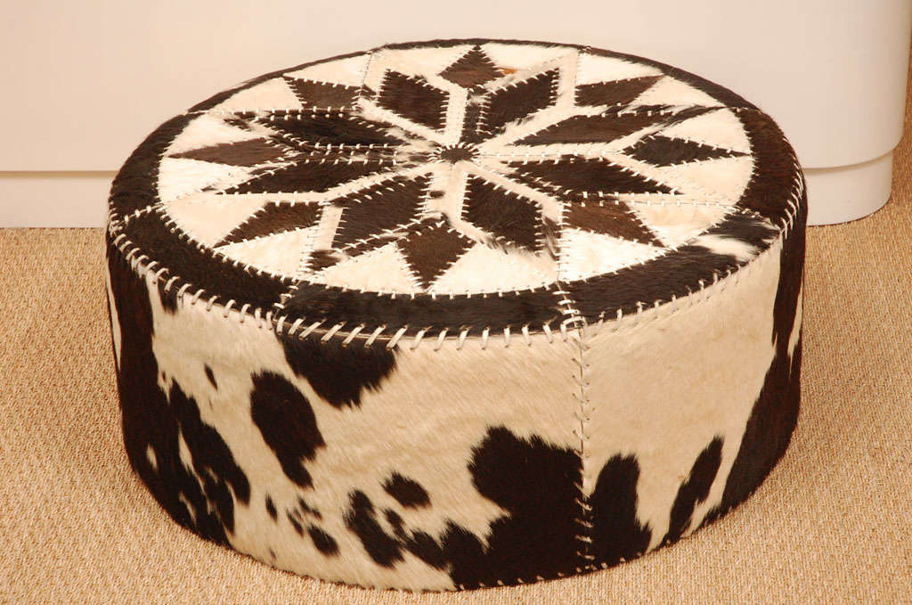 Great looking cowhide ottoman with leather stitching. All new upholstery interior