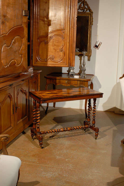 An English Charles II style centre table with Kingswood, pearwood and Cuban mahogany marquetry, barley twist base and casters from the mid-19th century. This English centre table features an exceptional inlaid top, featuring a floral marquetry