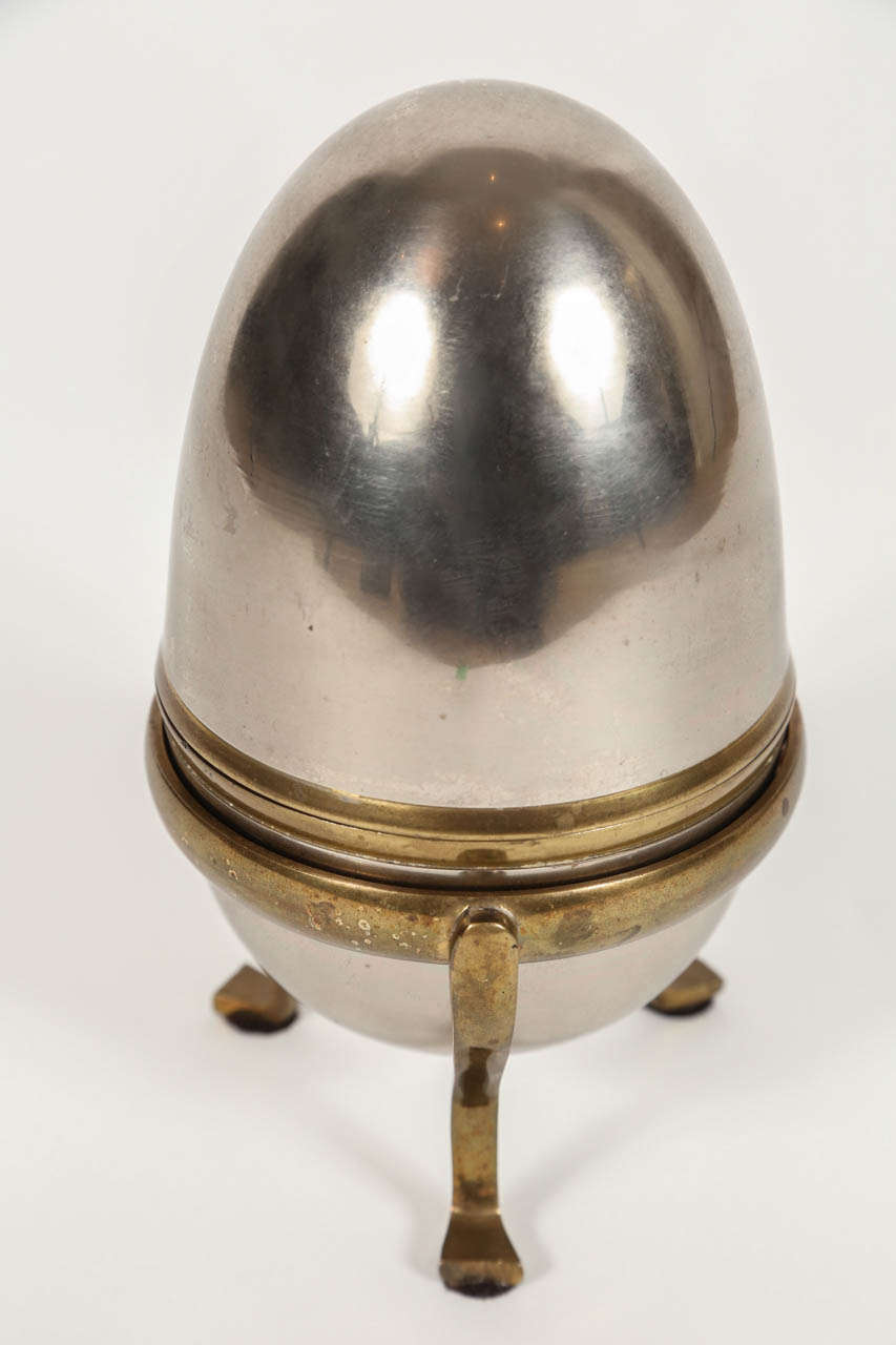 Brass and steel egg box on brass paw footed stand.