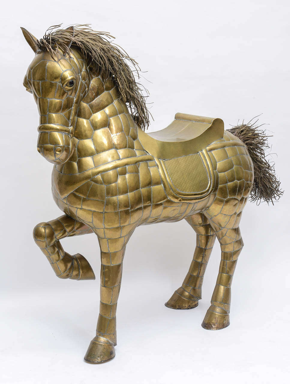 Fanciful large scale Bustamante horse with raised front leg - all saddled up.  The mane and tail are made with individual strips of brass.