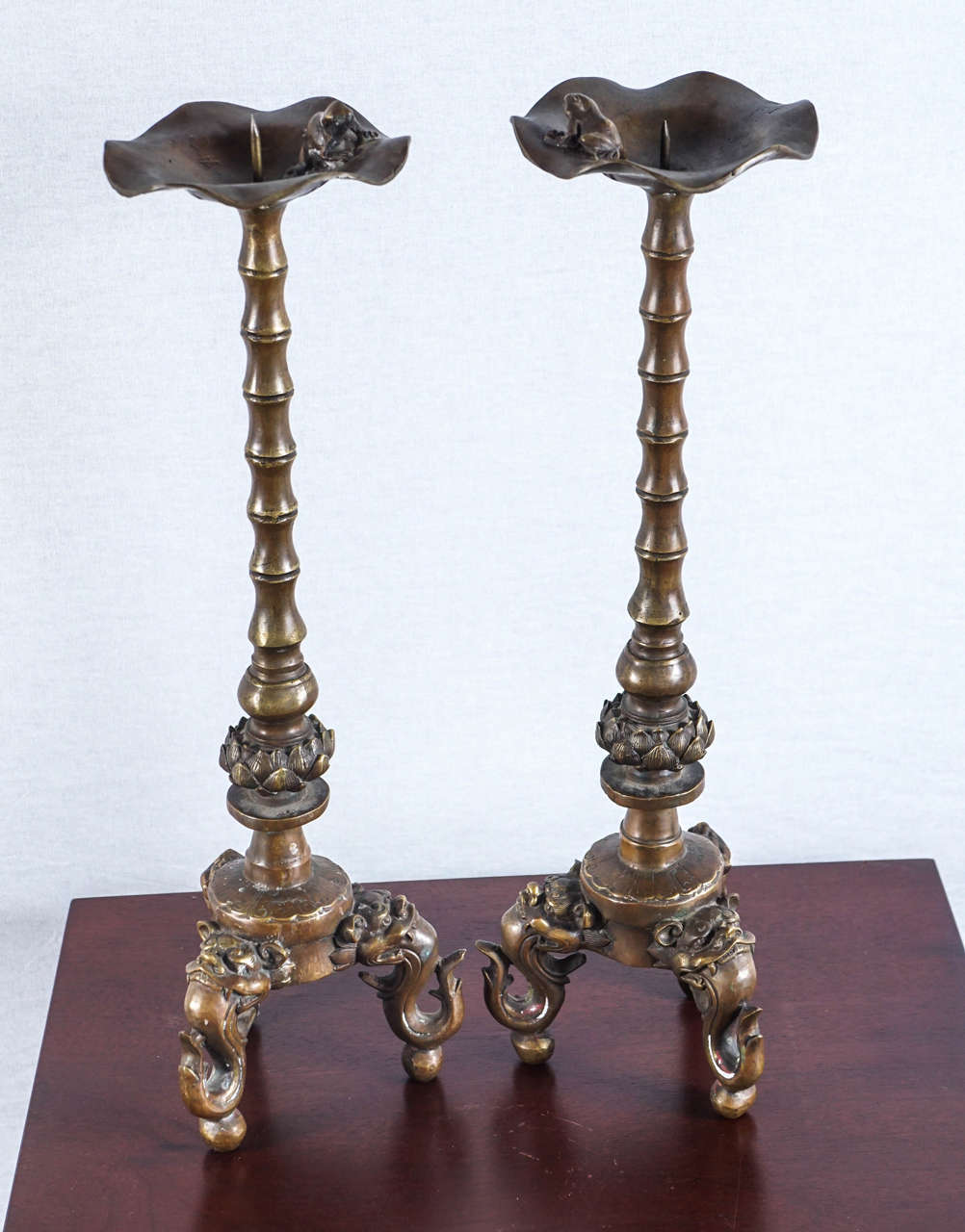 Hand-forged in Bronze, these ornate yet subtle candle-stands, sets the stage for Chinese Imperial guardians, lions, or “foo dogs”. At the top of the candle-stands, near the pricket, sits a frog on a lily pad shape. A frog, symbolizes fertility, as