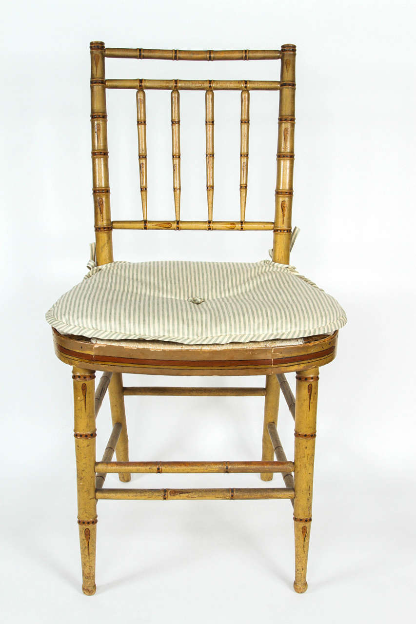 An English Regency faux bamboo side chair with new cushion.
